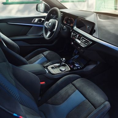 Sportovní interiér BMW řady 1. Kokpit BMW řady 1 s M sportovními sedadly, M koženým volantem a podsvíceným obložením interiéru.