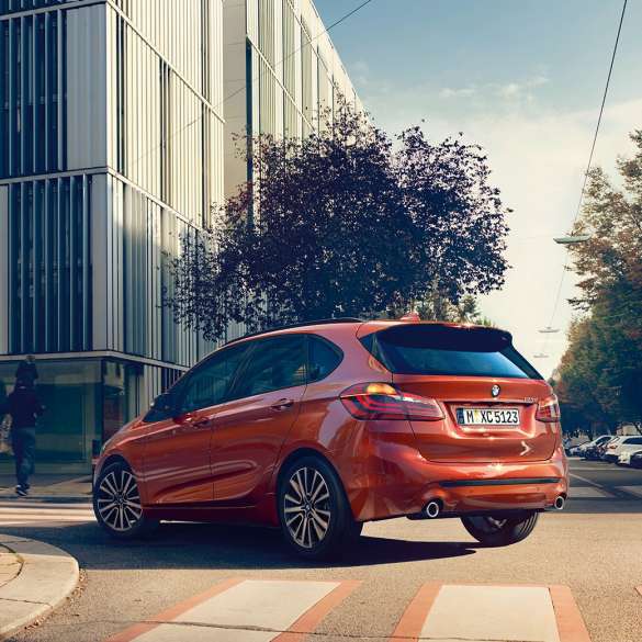 Jízdní dynamika BMW řady 2 Active Tourer Jízdní dynamika BMW řady 2 Active Tourer 220i F45 v metalické barvě Sunset Orange (oranžová) ze tříčtvrtečního pohledu zezadu