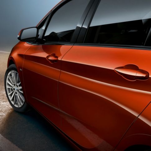 Detail na bok BMW řady 2 Active Tourer BMW řady 2 Active Tourer F45 v metalické barvě Sunset Orange (oranžová) detailní pohled na bok