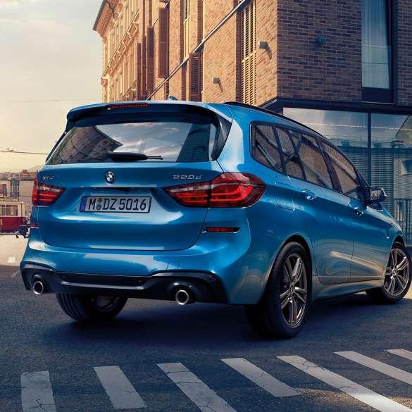 Exteriér BMW řady 2 Gran Tourer Exteriér BMW řady 2 Gran Tourer 220d xDrive F46 2018 v metalické barvě Misano Blue (modrá) ze tříčtvrtečního pohledu zezadu při jízdě centrem města