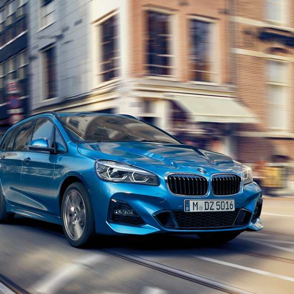 Jízdní dynamika BMW řady 2 Gran Tourer Jízdní dynamika BMW řady 2 Gran Tourer F46 2018 v metalické barvě Misano Blue (modrá) ze tříčtvrtečního pohledu zezadu při jízdě centrem města