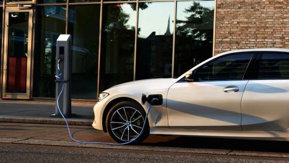 Plug-in hybridní BMW řady 3 Sedan 2021 G20 pohled z boku Plug-in hybridní BMW řady 3 Sedan 2021 G20 pohled z boku u nabíjecí stanice