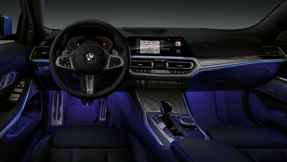 BMW řady 3 Sedan, prostorové osvětlení Přední pohled na řidičovo místo v BMW řady 3 Sedan s modrým prostorovým osvětlením prostoru pro nohy.