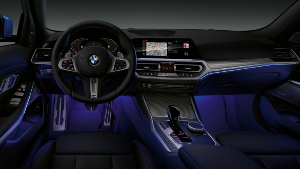 BMW řady 3 Sedan, prostorové osvětlení Přední pohled na řidičovo místo v BMW řady 3 Sedan s modrým prostorovým osvětlením prostoru pro nohy.