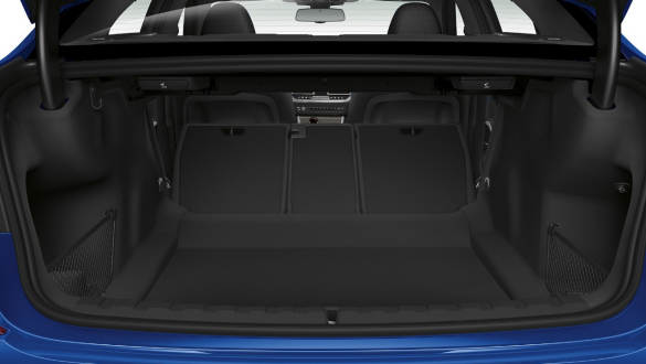 BMW řady 3 Sedan, průchozí nakládací system. Detailní pohled na otevřený zavazadlový prostor s napůl složeným opěradlem zadních sedadel.