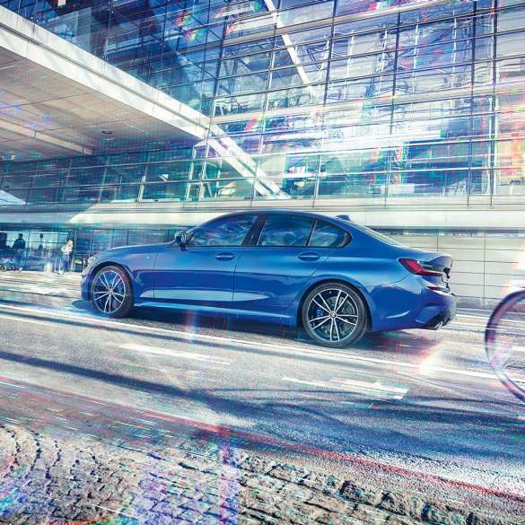 BMW řady 3 Sedan, pohled z boku. Statický záběr z boku na BMW řady 3 Sedan, stojící ve dne pod prosklenou budovou.