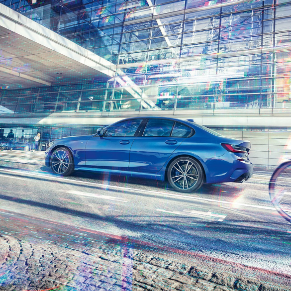 BMW řady 3 Sedan, pohled z boku. Statický záběr z boku na BMW řady 3 Sedan, stojící ve dne pod prosklenou budovou.