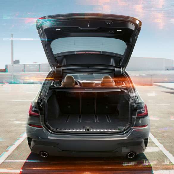 BMW řady 3 Touring, pohled zezadu s otevřeným zavazadlovým prostorem BMW řady 3 Touring, pohled zezadu s otevřeným zavazadlovým prostorem na parkovací místo v městském prostředí