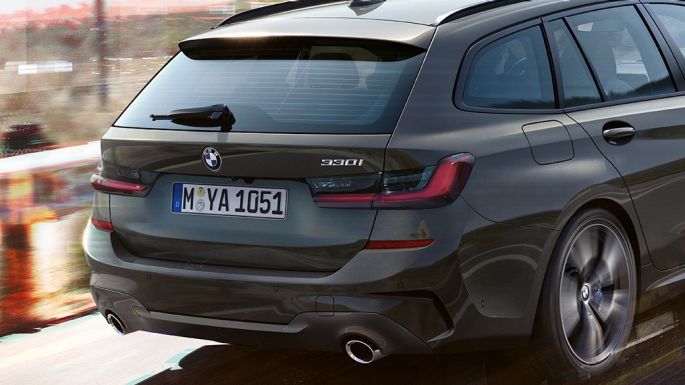 BMW řady 3 Touring, tříčtvrteční jízdní záběr zezadu BMW řady 3 Touring, tříčtvrteční jízdní záběr zezadu na mostě ve venkovském prostředí