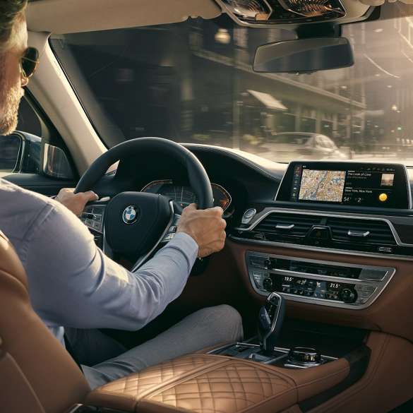 Funkce konektivity BMW řady 7 Sedan BMW řady 7 Sedan: muž sedí v BMW a používá funkce konektivity