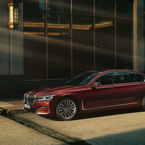 BMW řady 7 Sedan, boční pohled Boční pohled na červené BMW řady 7 Sedan Individual stojící před městskou zástavbou