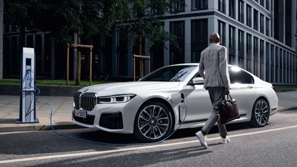 Plug-in hybridní BMW řady 7 Sedan G11 G12 pohled z boku při nabíjení Plug-in hybridní BMW řady 7 Sedan G11 G12 pohled z boku při nabíjení s modelem