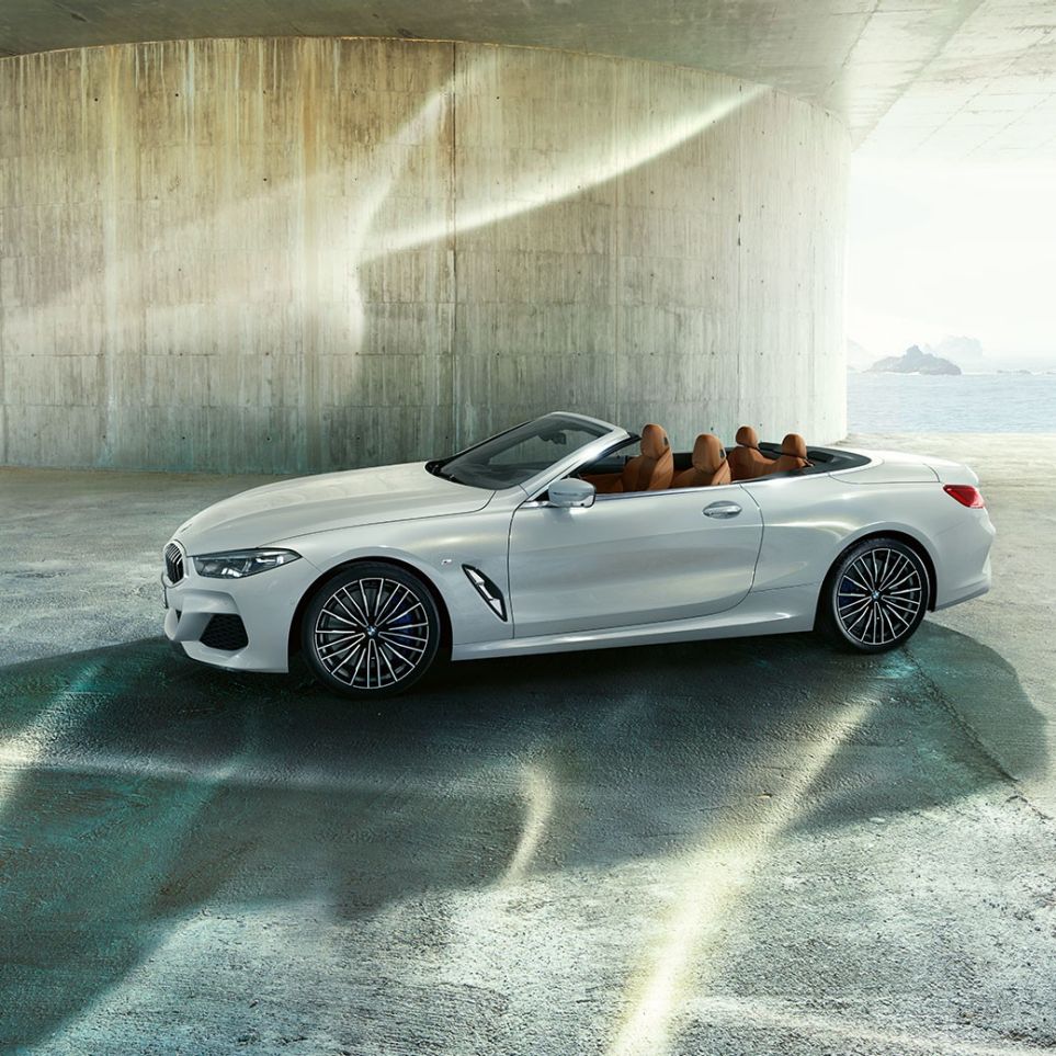 BMW M850i xDrive v metalickém laku Mineral White, boční pohled s otevřenou střechou. BMW M850i xDrive v metalickém laku Mineral White, boční pohled s otevřenou střechou.