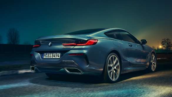 Koncovky výfuku a zadní kola. BMW řady 8 Coupé, pohled zezadu od země, koncovky výfuku a zadní kola.
