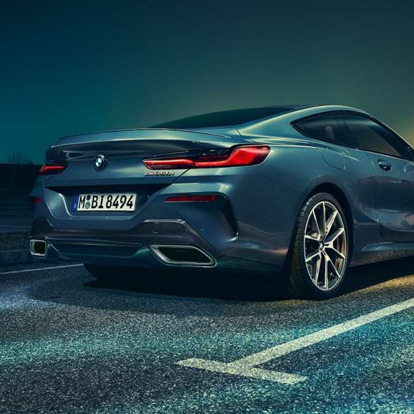 BMW řady 8 Coupé, tříčtvrteční pohled zezadu. BMW řady 8 Coupé, tříčtvrteční pohled zezadu, stojící před noční scenérií.