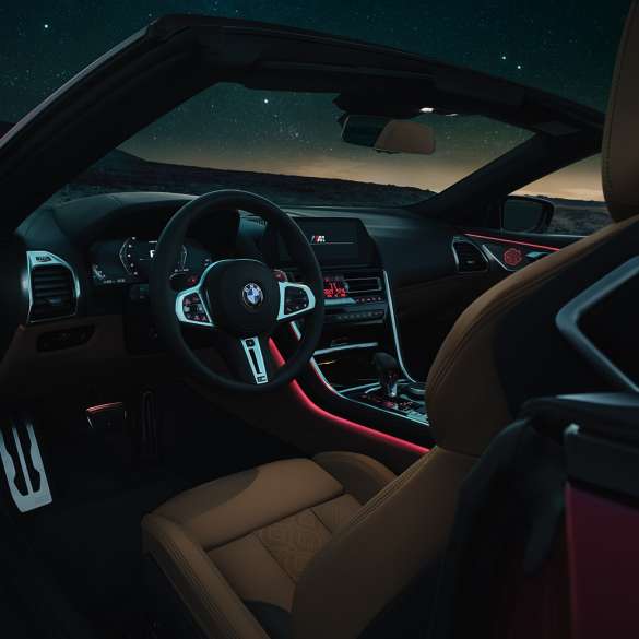 BMW M8 Competition Cabrio, kokpit BMW M8 Competition Cabrio, noční kokpit s M koženým volantem a červeným prostorovým osvětlením.