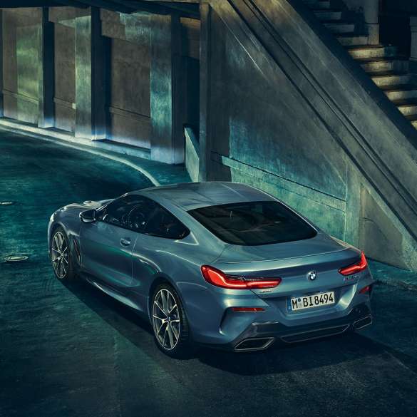 BMW M850i xDrive Coupé, tříčtvrteční pohled zleva. BMW M850i xDrive Coupé v metalické barvě Barcelona Blue, tříčtvrteční pohled zleva, staticky v noci.