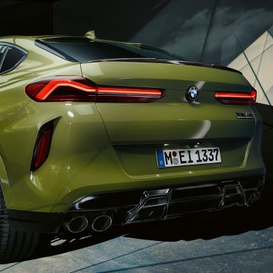 Tříčtvrteční zadní pohled na BMW X6 M Competition Tříčtvrteční zadní pohled na BMW X6 M Competition F96 ve speciální barvě BMW Individual Urban Green s M sportovním výfukem