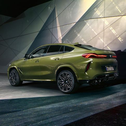 Tříčtvrteční zadní pohled na BMW X6 M Competition Tříčtvrteční zadní pohled na BMW X6 M Competition F96 ve speciální barvě BMW Individual Urban Green s M sportovním výfukem