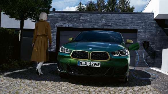 Plug-in hybridní BMW X2 xDrive25e F39 pohled zepředu před garáží Plug-in hybridní BMW X2 xDrive25e F39 pohled zepředu před garáží s modelem