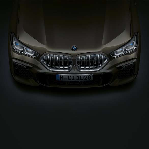 Příď BMW X6. Detailní pohled z ptačí perspektivy na přední část BMW X6 s BMW maskou chladiče Iconic Glow.