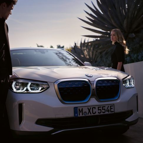 BMW iX3 G08 tříčtvrteční pohled zepředu s BMW i maskou chladiče ve tvaru ledvinek BMW iX3 G08 2020 v metalické barvě Mineral White (bílá) tříčtvrteční pohled zepředu s BMW i maskou chladiče ve tvaru ledvinek