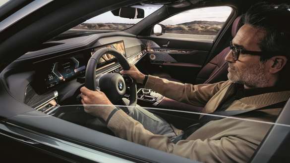 Muž v BMW s rukama na volantu Muž řídí BMW s rukama na volantu
