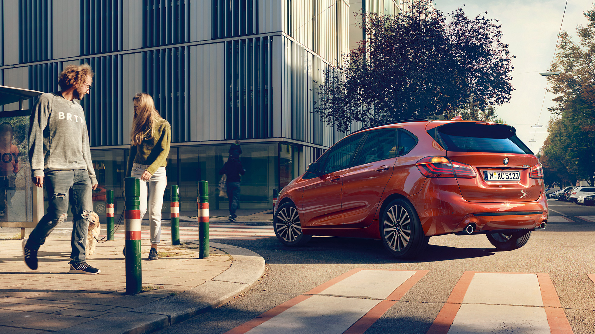 Jízdní dynamika BMW řady 2 Active Tourer Jízdní dynamika BMW řady 2 Active Tourer 220i F45 v metalické barvě Sunset Orange (oranžová) ze tříčtvrtečního pohledu zezadu