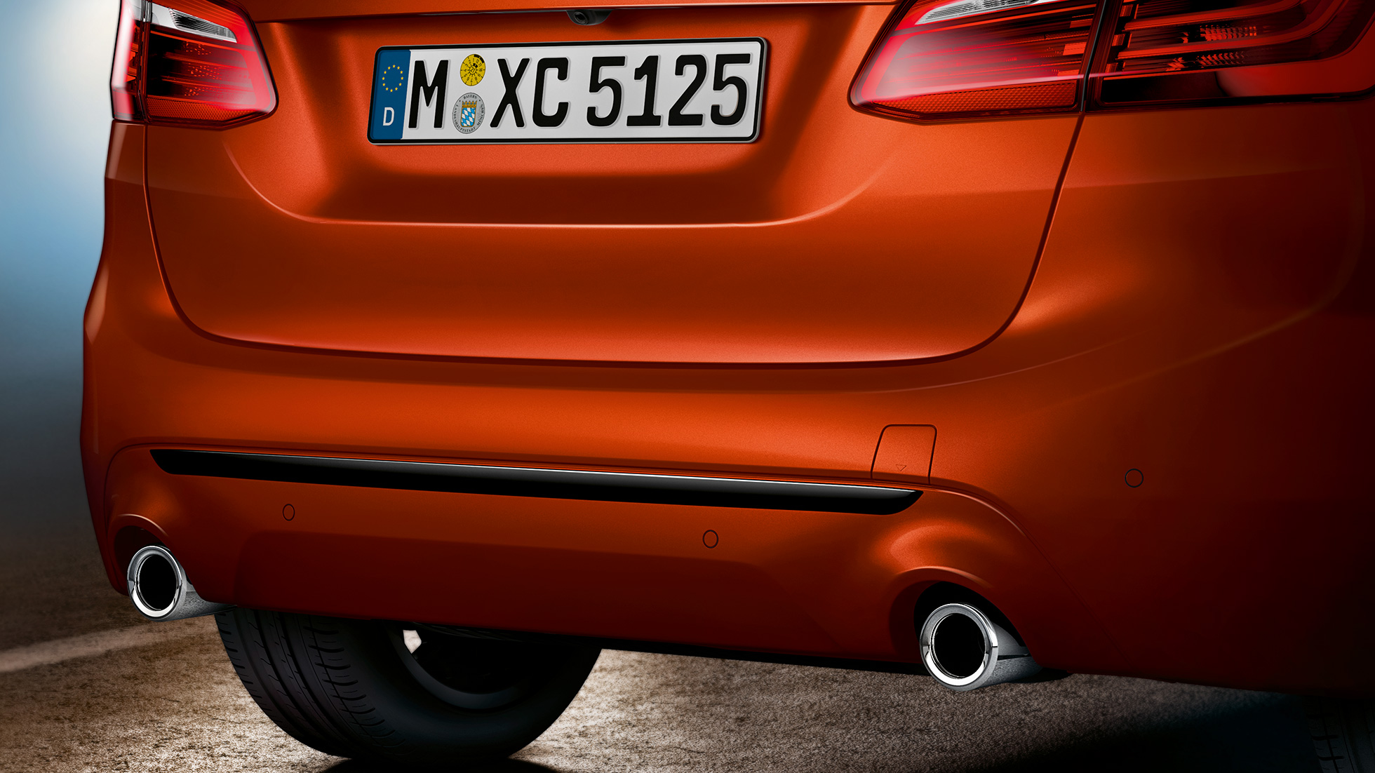 Zadní část BMW řady 2 Active Tourer Zadní část BMW řady 2 Active Tourer 220i F45 v metalické barvě Sunset Orange (oranžová) detailní pohled na záď