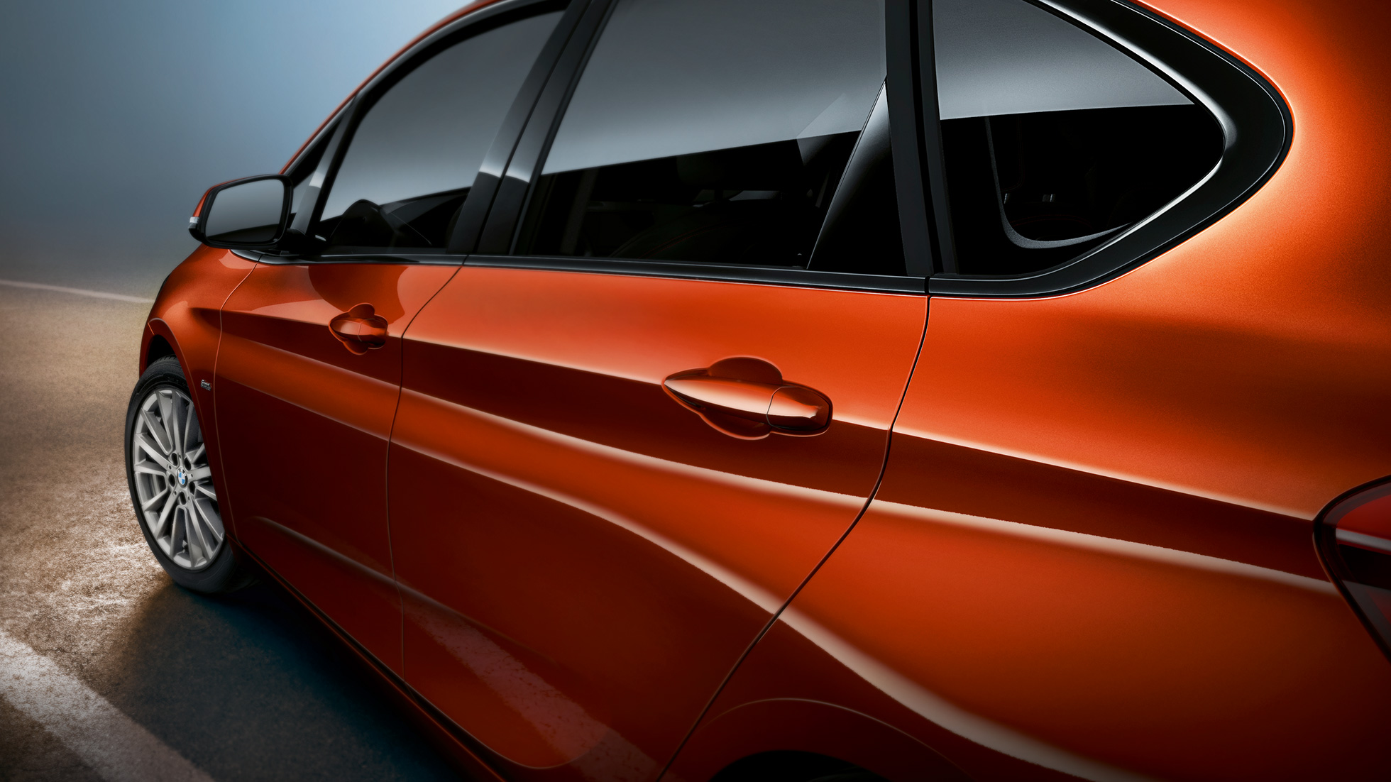 Detail na bok BMW řady 2 Active Tourer BMW řady 2 Active Tourer F45 v metalické barvě Sunset Orange (oranžová) detailní pohled na bok