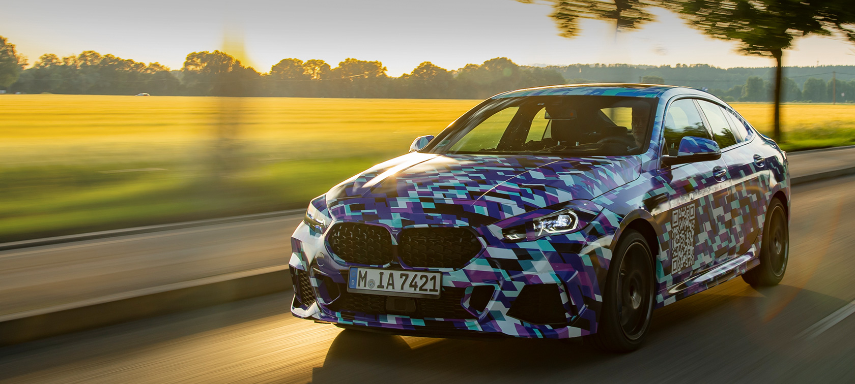 První BMW 2 Series Gran Coupé BMW řady 2 Gran Coupé F44, tříčtvrteční pohled zepředu na maskovaný prototyp, jízdní záběr