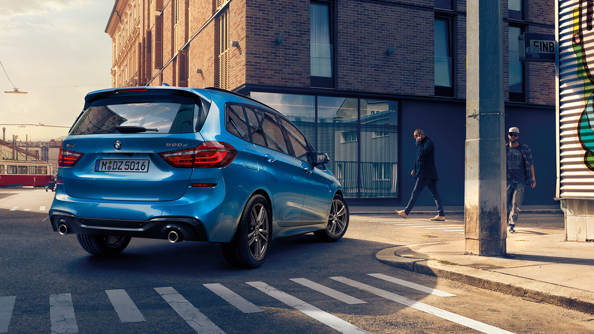 Exteriér BMW řady 2 Gran Tourer Exteriér BMW řady 2 Gran Tourer 220d xDrive F46 2018 v metalické barvě Misano Blue (modrá) ze tříčtvrtečního pohledu zezadu při jízdě centrem města