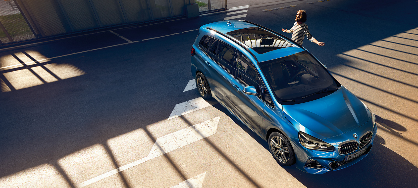 BMW řady 2 Gran Tourer s rodinou Rodina stojí vedle BMW řady 2 Gran Tourer F46 2018 v metalické barvě Misano Blue (modrá)