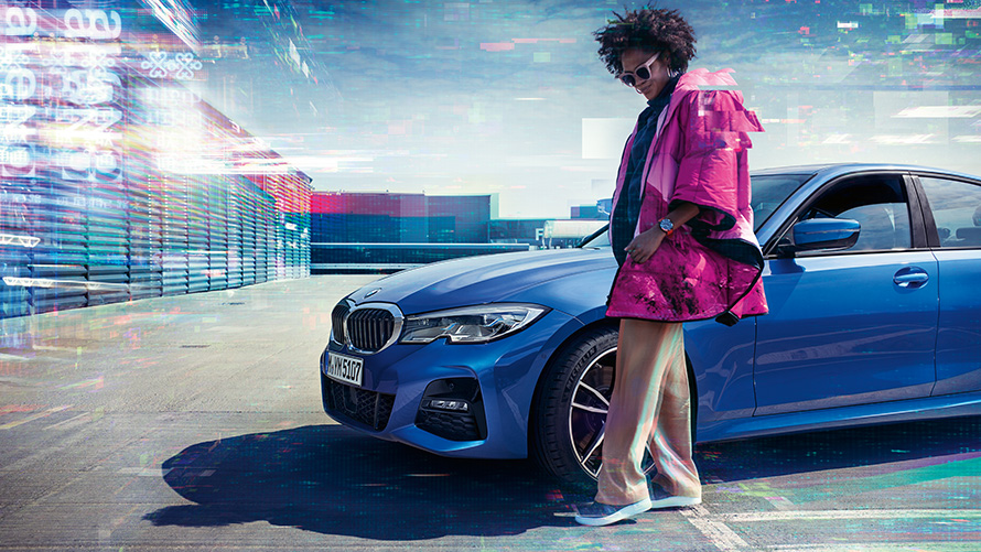 BMW řady 3 Sedan (G20), metalický lak Portimao Blue (modrá), 7/8 zepředu BMW řady 3 Sedan (G20), metalický lak Portimao Blue (modrá), 7/8 zepředu při parkování s osobou v popředí