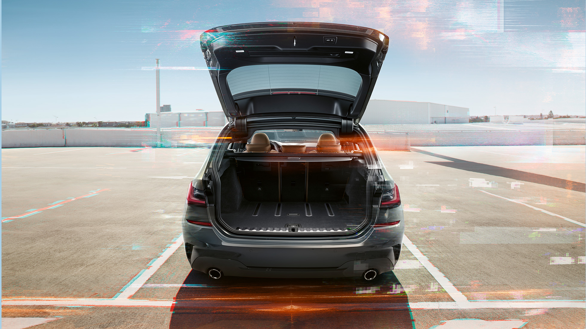 BMW řady 3 Touring, pohled zezadu s otevřeným zavazadlovým prostorem BMW řady 3 Touring, pohled zezadu s otevřeným zavazadlovým prostorem na parkovací místo v městském prostředí