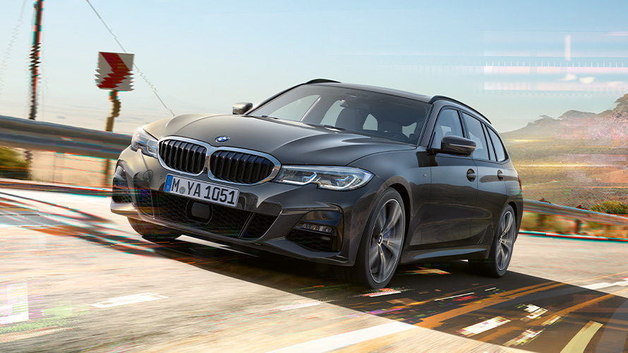 BMW řady 3 Touring (G21), šedá Dravit Grey, jízdní tříčtvrteční záběr zepředu BMW řady 3 Touring (G21), šedá Dravit Grey, jízdní tříčtvrteční záběr zepředu ve venkovském prostředí