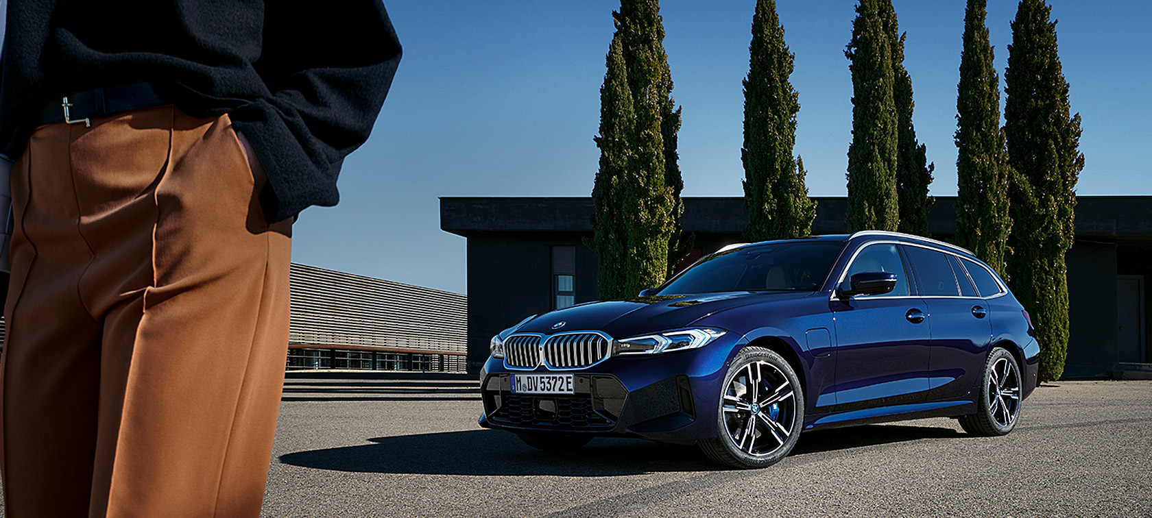 BMW řady 3 Touring LCI G21 metalický lak Tansanite Blue II (modrá) tříčtvrteční statický pohled zepředu před stromy