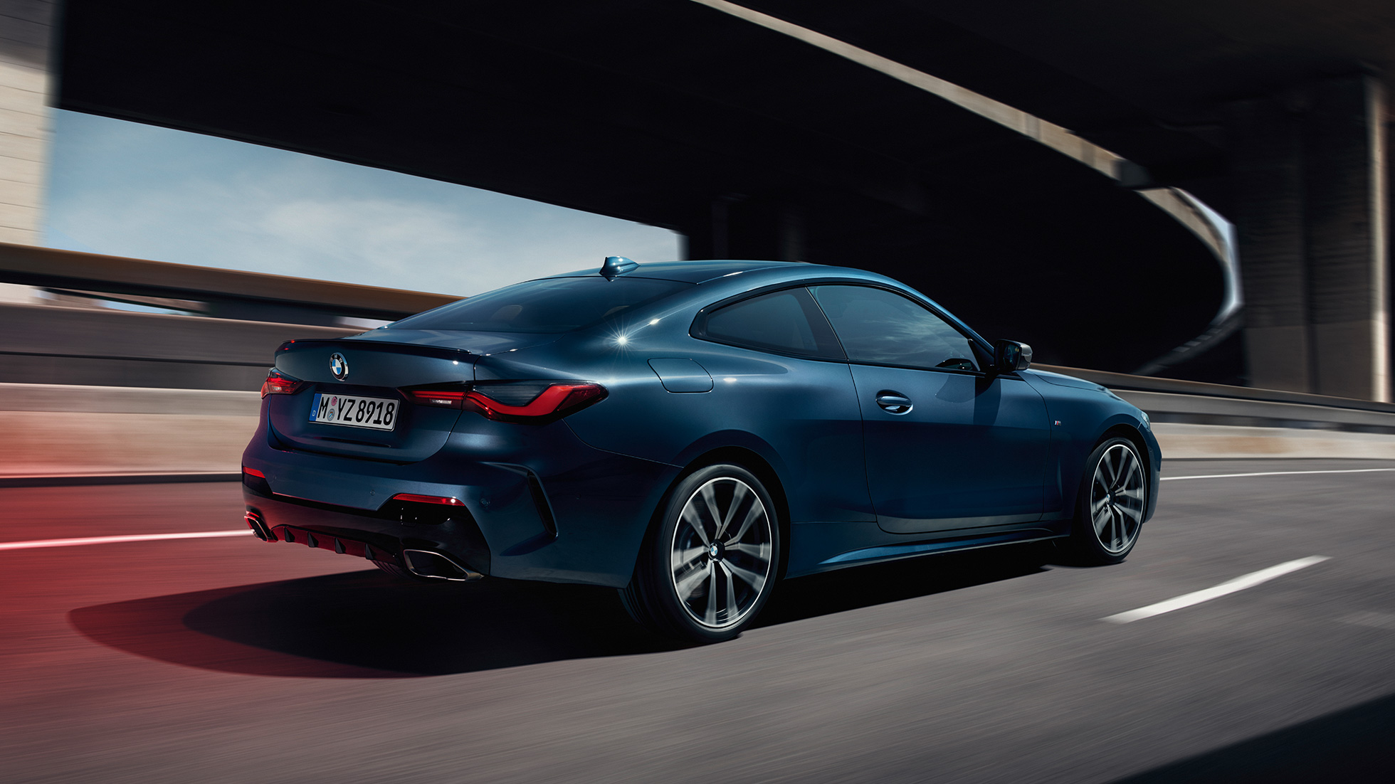 Tříčtvrteční pohled z boku BMW řady 4 Coupé G22 2020 BMW řady 4 Coupé G22 2020 v metalické barvě Arctic Race Blue (modrá) ze tříčtvrtečního pohledu z boku v pohybu