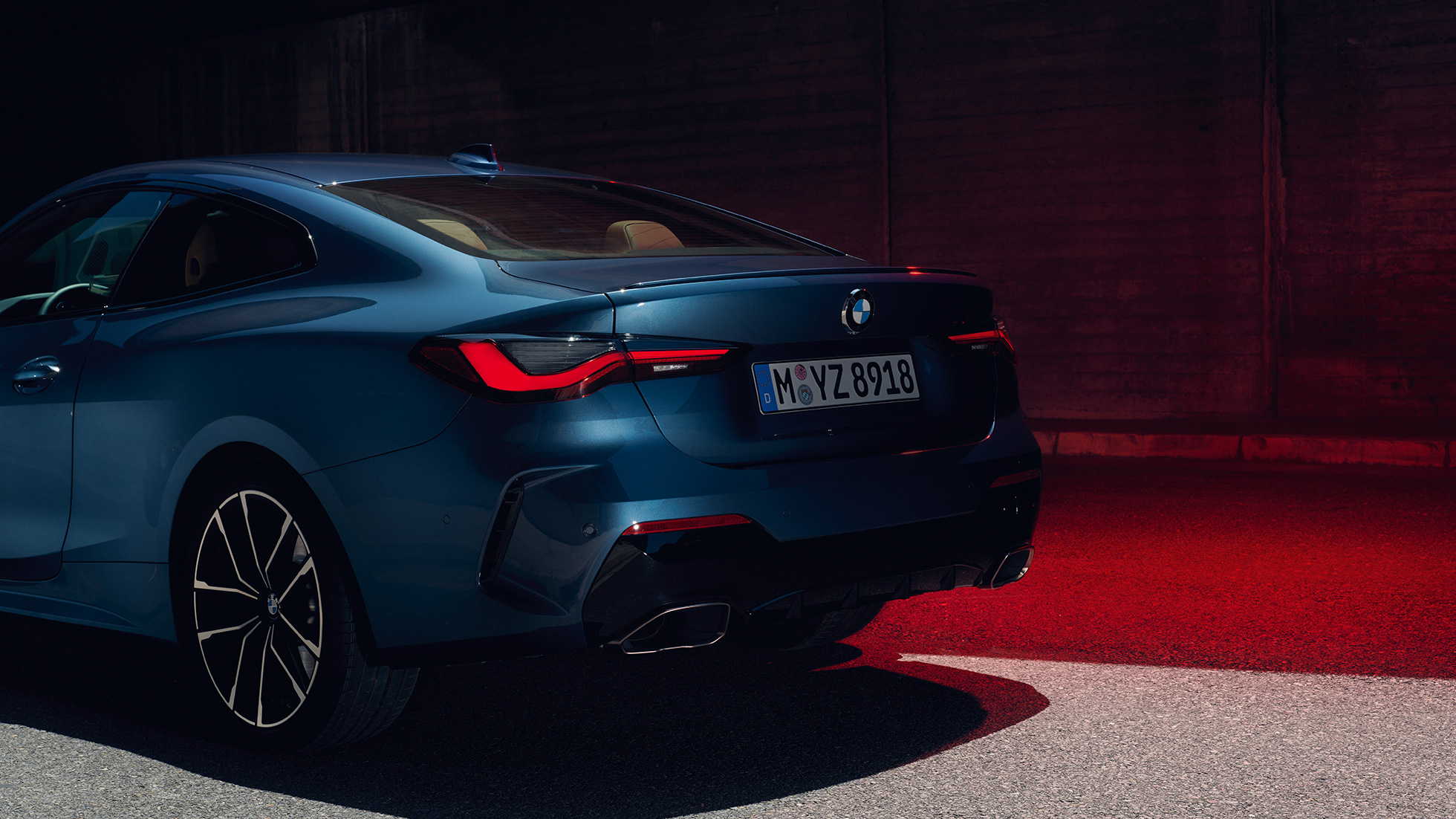 Tříčtvrteční pohled zezadu BMW řady 4 Coupé G22 2020 BMW řady 4 Coupé G22 2020 v metalické barvě Arctic Race Blue (modrá) ze tříčtvrtečního pohledu zezadu s pohledem na koncovky výfuku