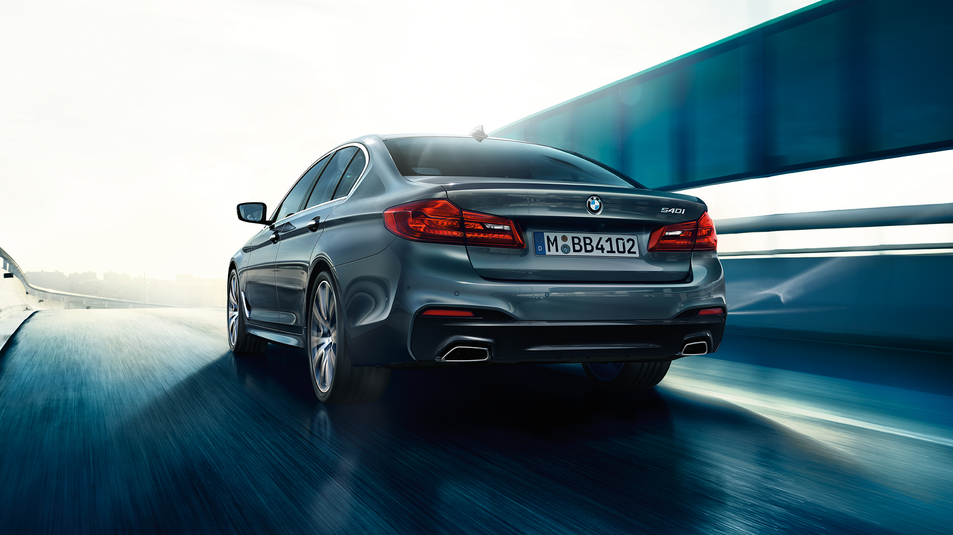 Zadní část BMW řady 5 Sedan BMW řady 5 Sedan 540i Sedan G30 v metalické barvě Bluestone (šedá) při pohledu zezadu