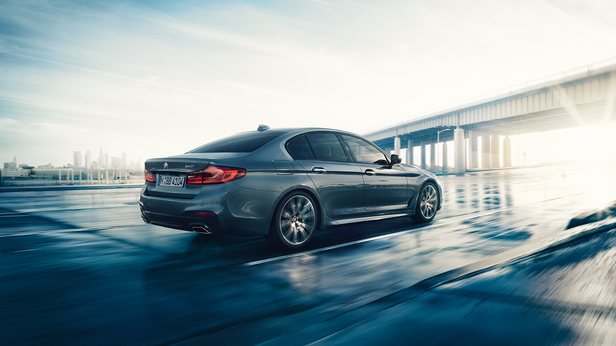 Zadní část BMW řady 5 Sedan Zadní část BMW řady 5 Sedan speciality 540i Sedan G30 v metalické barvě Bluestone ze tříčtvrtečního pohledu zezadu