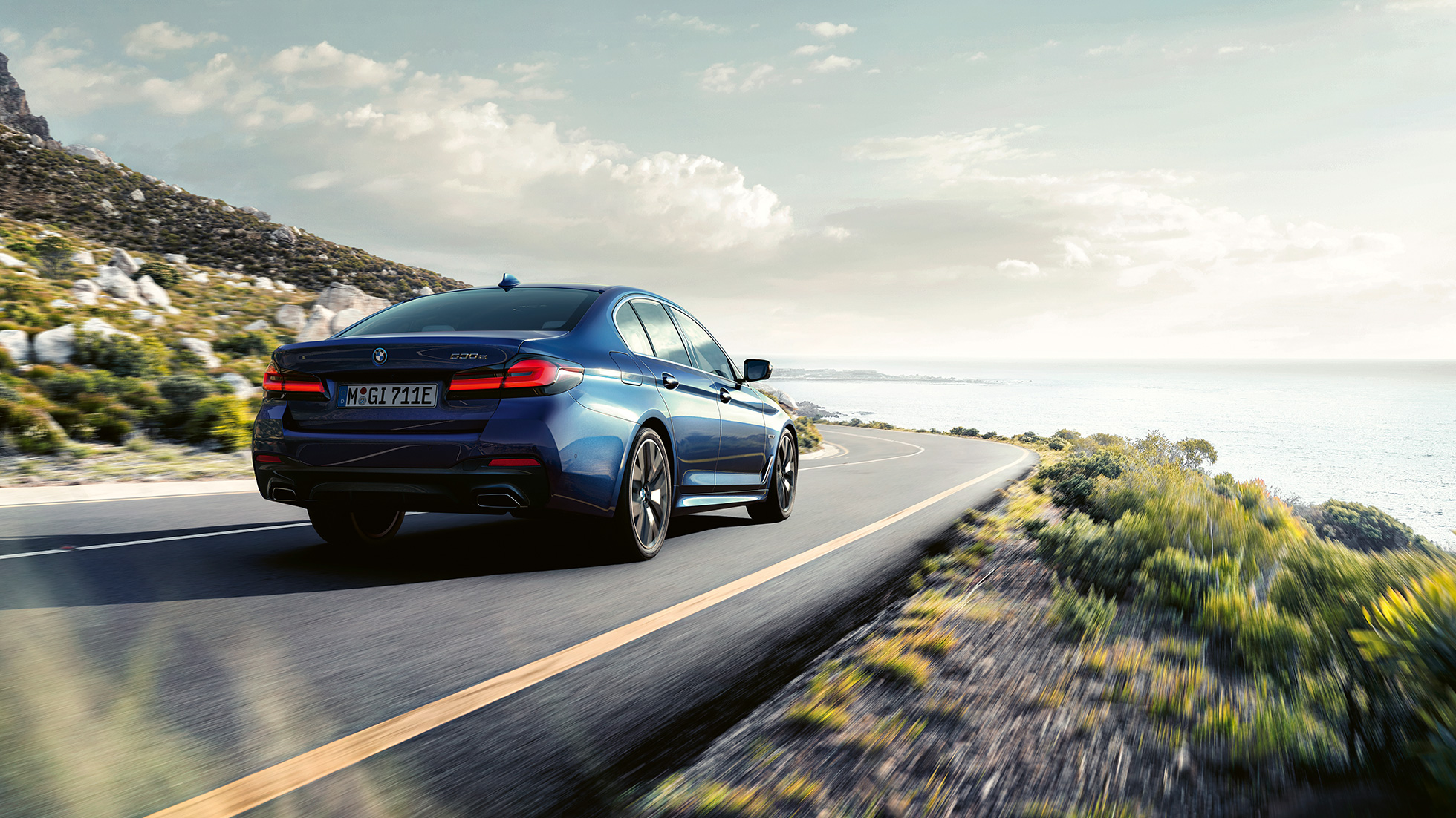 Jízdní dynamika BMW řady 5 Sedan G30 Jízdní dynamika BMW řady 5 Sedan G30 Phytonic Blue (modrá) tříčtvrteční pohled zezadu jízdní záběr