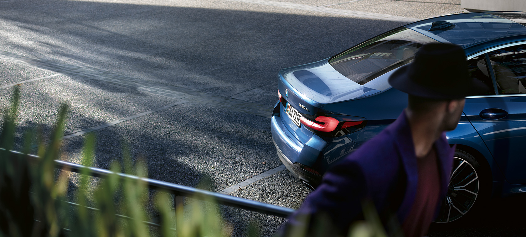 Muž stojící za parkujícím BMW BMW řady 5 Sedan G30 BMW řady 5 Sedan G30 Facelift 2020 muž stojící za parkujícím BMW