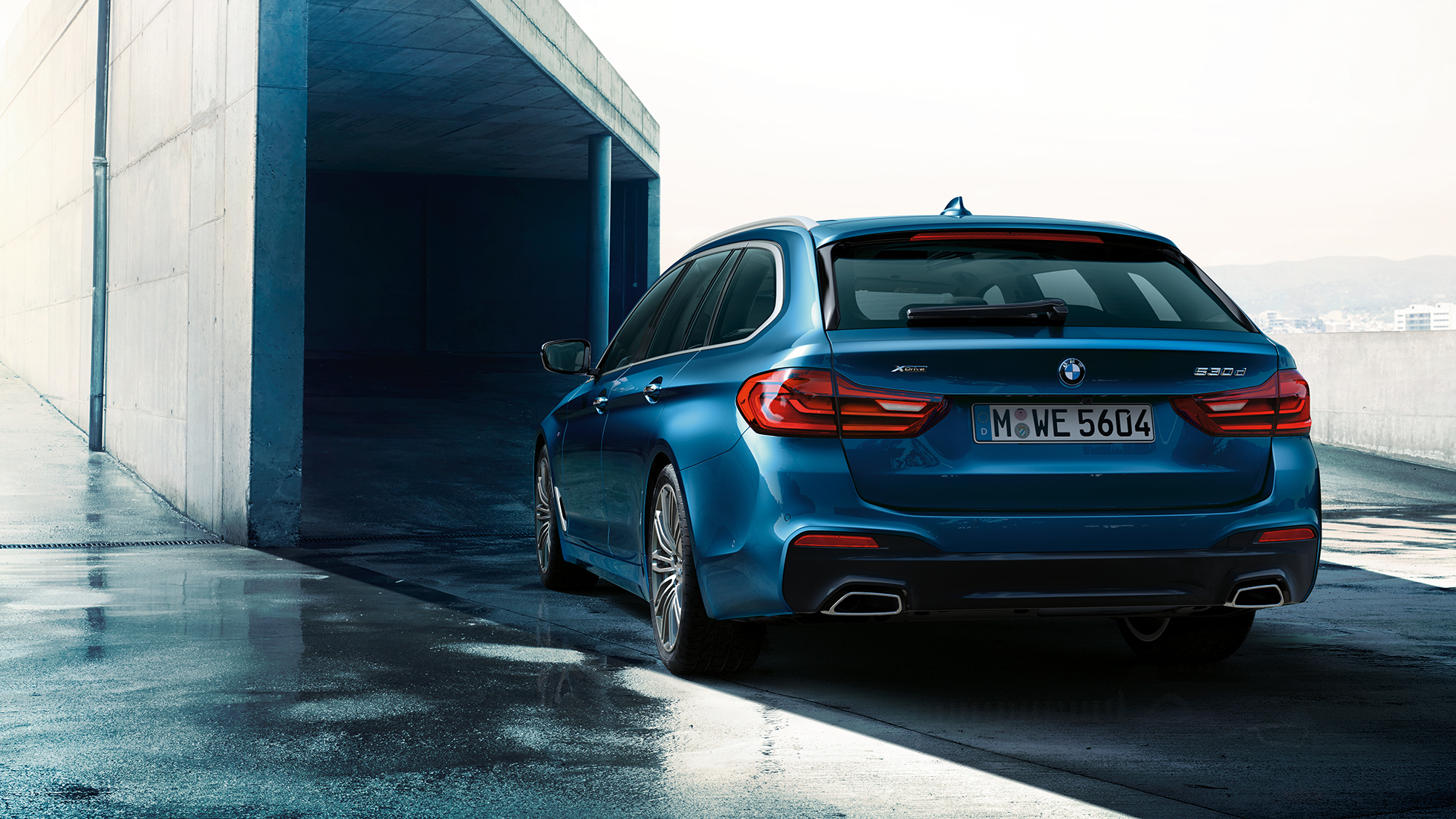Design zadní části BMW řady 5 Touring BMW řady 5 Touring 530d xDrive Touring G31 v metalickém laku Mediterranean Blue (modrá) ze tříčtvrtečního pohledu zezadu