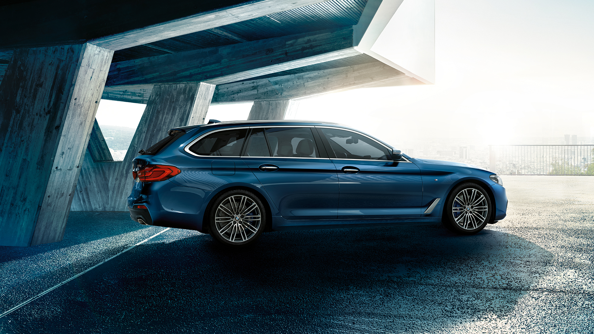 Design boční části BMW řady 5 Touring BMW řady 5 Touring 530d xDrive Touring G31 v metalickém laku Mediterranean Blue (modrá) ze tříčtvrtečního pohledu z boku