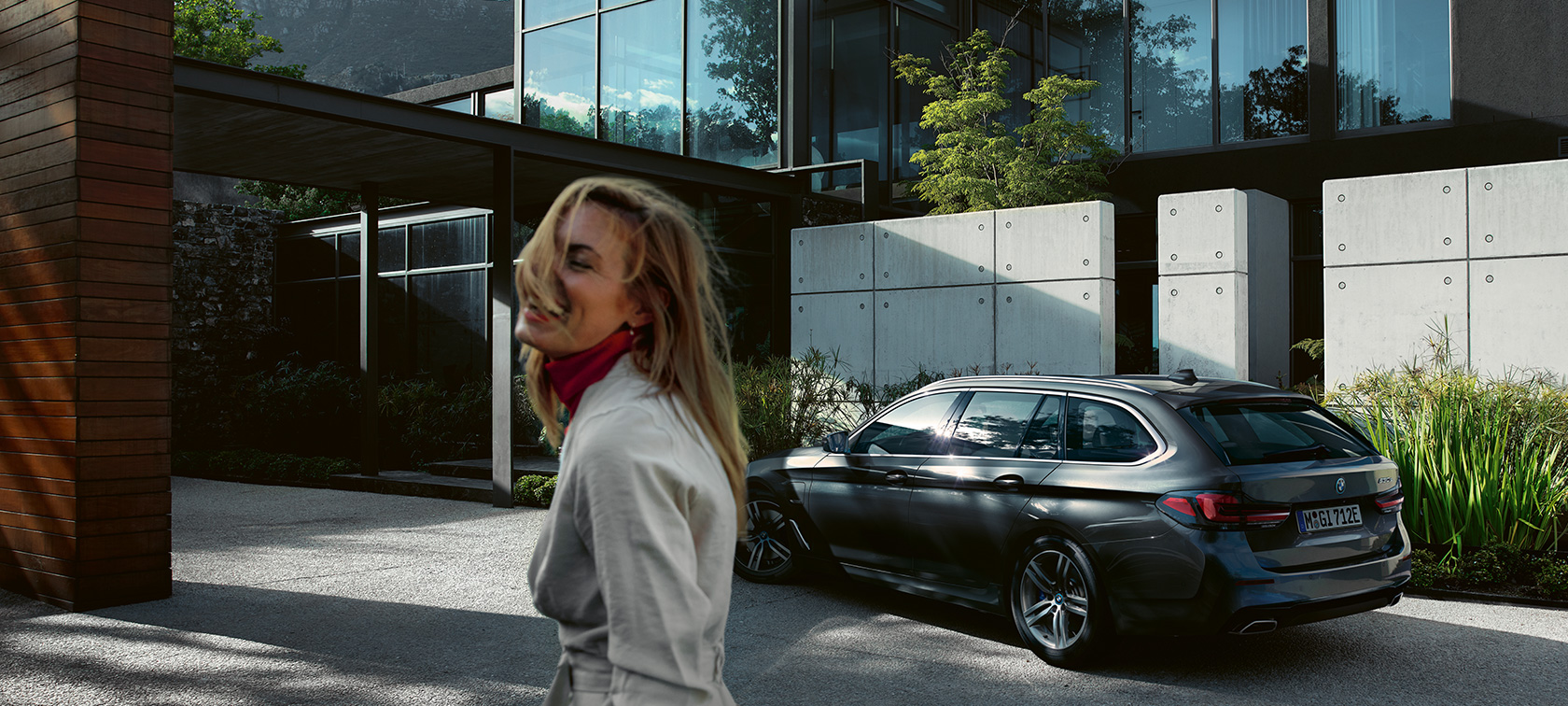 Žena před parkujícím BMW řady 5 Touring BMW řady 5 Touring G31 Facelift 2020 žena před parkujícím BMW