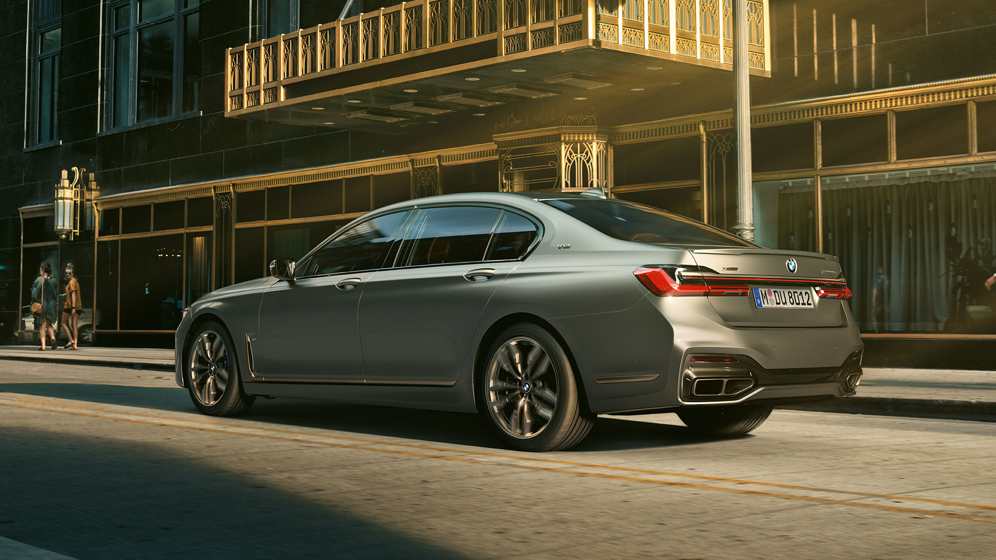 BMW M760Li xDrive s motorem V12 BMW M760Li xDrive v bočním zadním pohledu stojící před mrakodrapy městské zástavby
