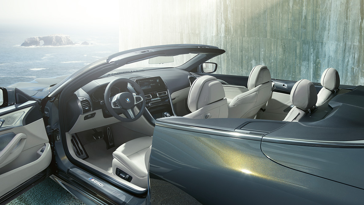BMW M850i xDrive s metalickým lakem Dravit Grey, interiér, plátěná střecha a otevřené dveře. BMW M850i xDrive s metalickým lakem Dravit Grey, interiér, plátěná střecha a otevřené dveře.