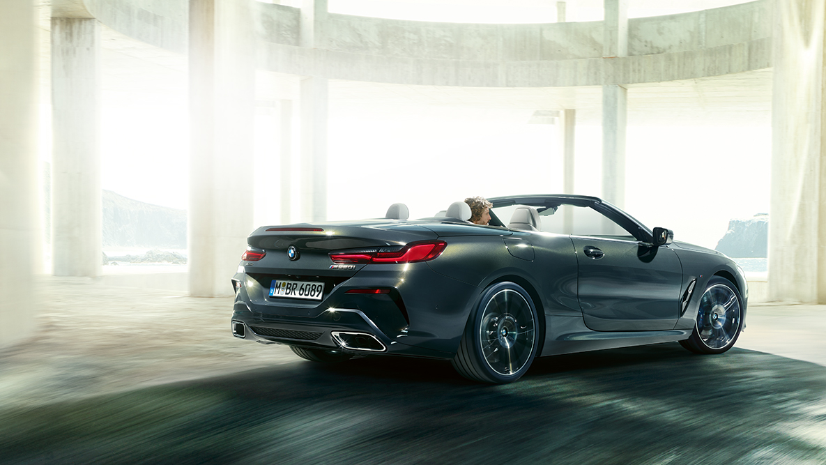 BMW M850i xDrive boční pohled za jízdy s otevřenou střechou. BMW M850i xDrive boční pohled za jízdy s otevřenou střechou.