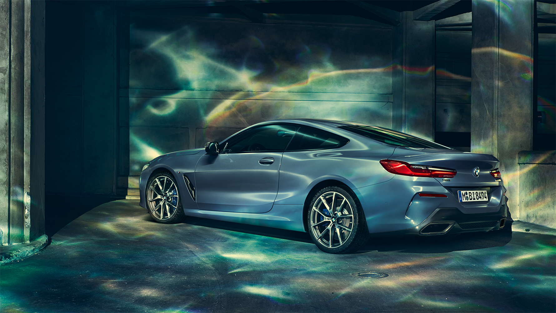 BMW řady 8 Coupé, pohled zezadu ze tří čtvrtin Statická fotografie BMW řady 8 Coupé zezadu ze tří čtvrtin v nočním městském prostředí.